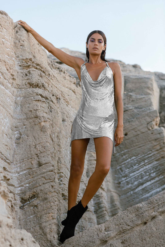 Model showcasing a silver backless chainmail dress, perfect for glamorous evenings