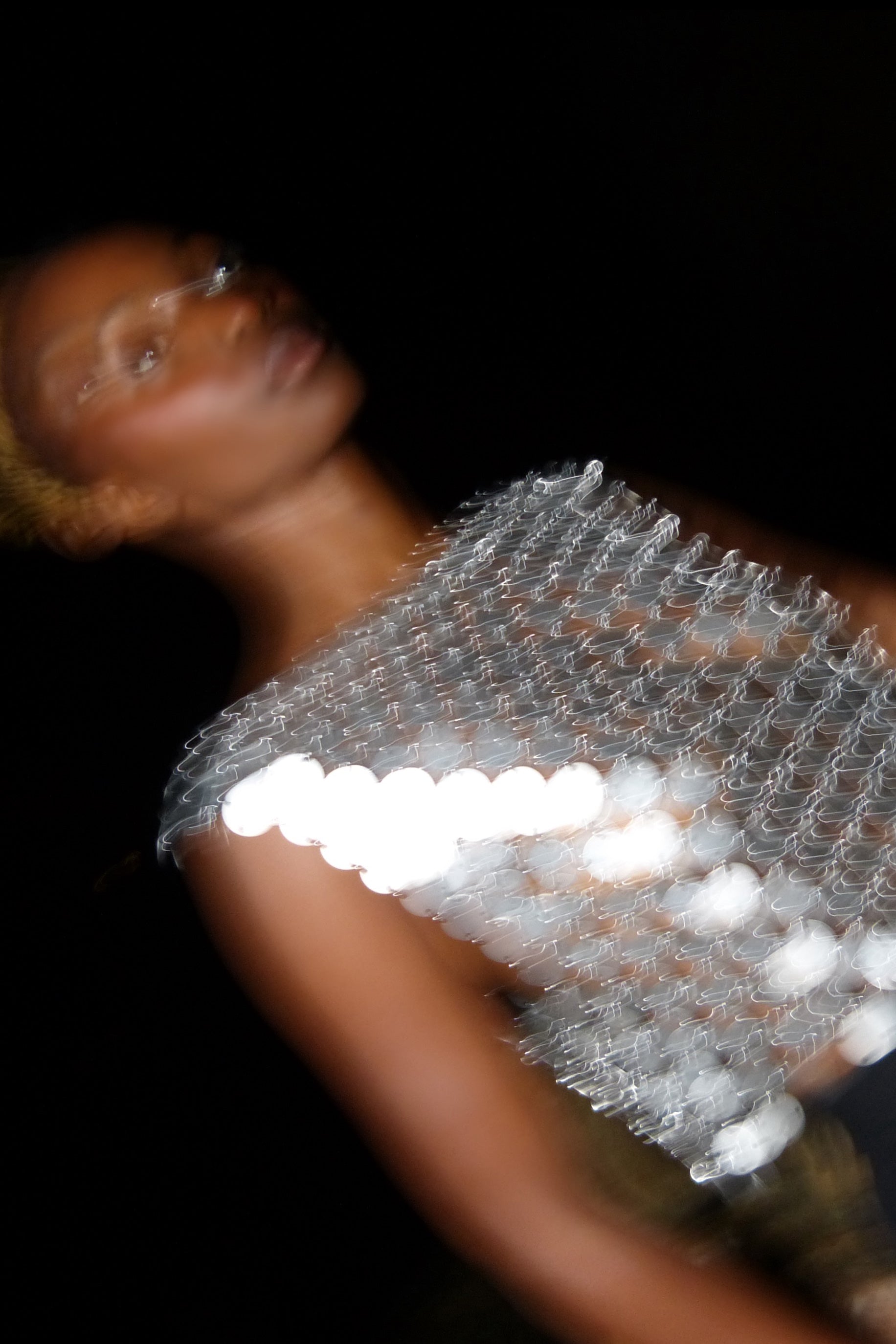 Close-up of the silver metallic chainmail fabric on the boat neck top, highlighting its intricate craftsmanship.